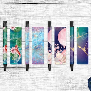 May include: Six black pens with different colorful designs. The designs include koi fish, cherry blossoms, a moon, and marble.