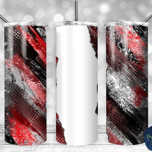 Peut inclure: Trois gobelets en acier inoxydable avec un motif abstrait rouge, noir et argent. Le gobelet de gauche et de droite ont le motif, tandis que le gobelet du milieu est vide.