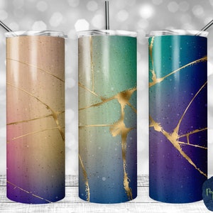 May include: Three stainless steel tumblers with a gradient color design and gold accents. The tumblers are in shades of pink, blue, and purple.