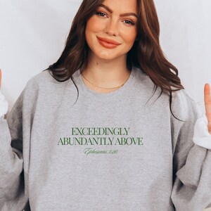 May include: A gray sweatshirt with the text "Exceedingly Abundantly Above" and the scripture reference "Ephesians 3:20" in green.