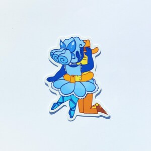 May include: A die-cut sticker featuring a blue-skinned figure with curly hair and a light blue ruffled skirt embracing an orange-skinned figure wearing a brown hat and brown boots. The blue figure has butterfly-like accents in their hair.