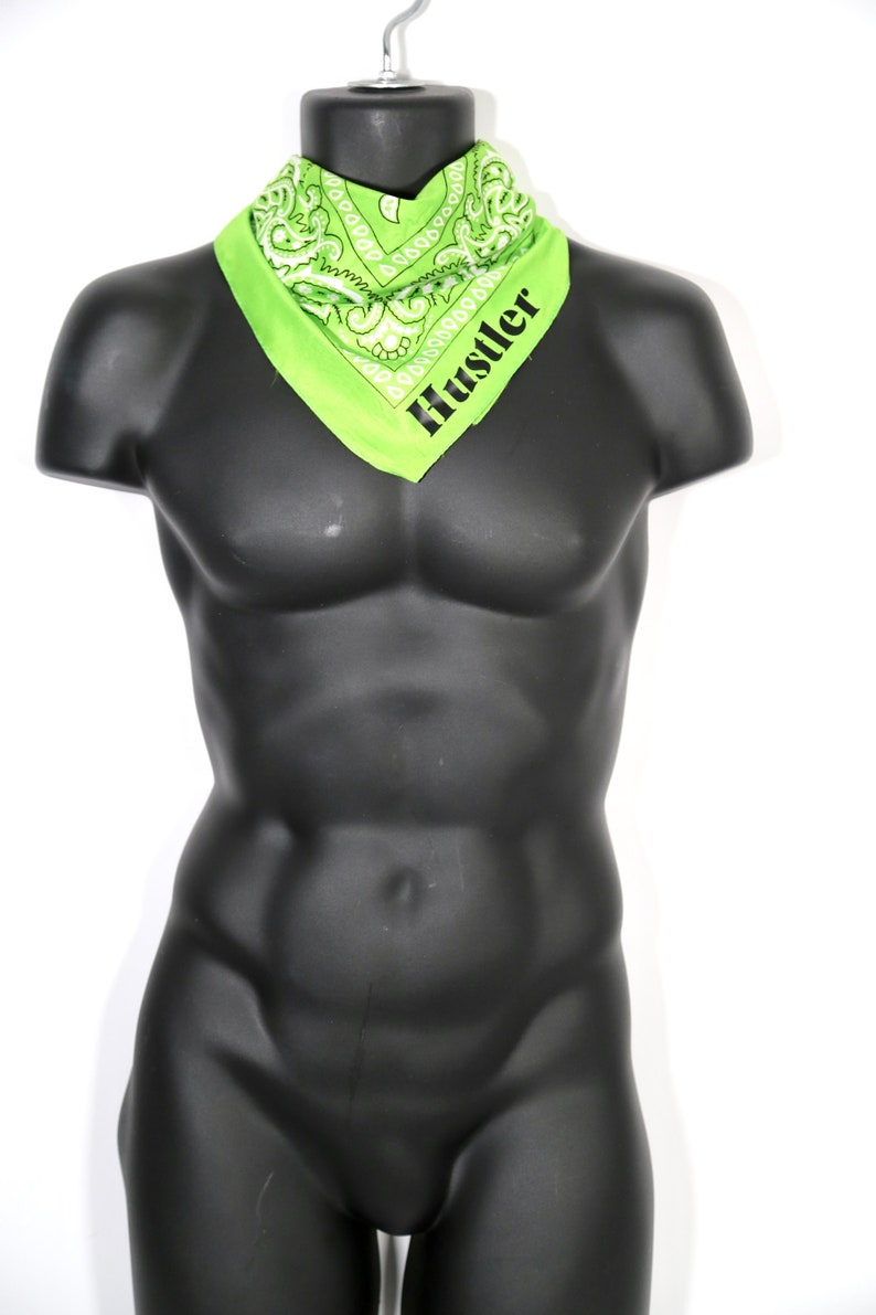 May include: A green bandana with a white paisley pattern and the word "Hustler" printed in black.