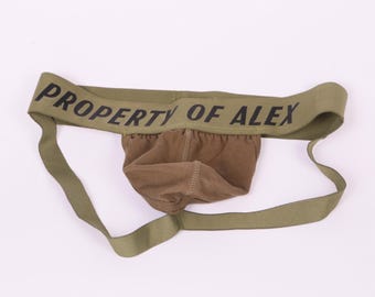 May include: Green jockstrap with the text "PROPERTY OF ALEX" printed on the waistband.