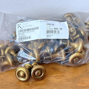 May include: A bag of 24 brass cabinet knobs, 3/4 inch in size. The bag is labeled with the item number A800-BN and the text "Nipple Knob".