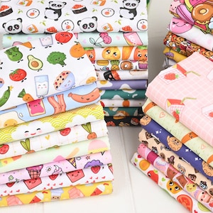 以下が含まれることがあります： 様々な食べ物をテーマにした模様のカラフルな生地の山。デザインには、寿司、パンダ、果物、野菜、デザート、飲み物が含まれます。生地は白、ピンク、黄色、青など、さまざまな色があります。