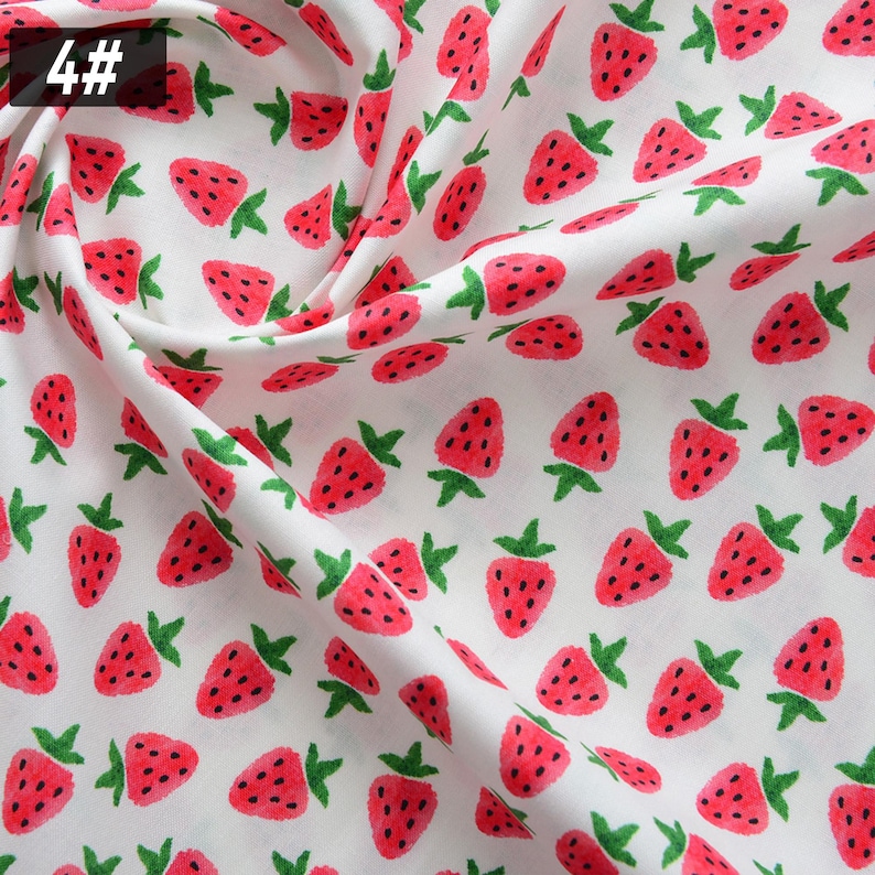 Puede incluir: Tela blanca con un patr&oacute;n repetido de fresas rojas y hojas verdes. Las fresas tienen semillas negras y est&aacute;n dispersas por la tela. El n&uacute;mero "4#" est&aacute; en la esquina superior izquierda.