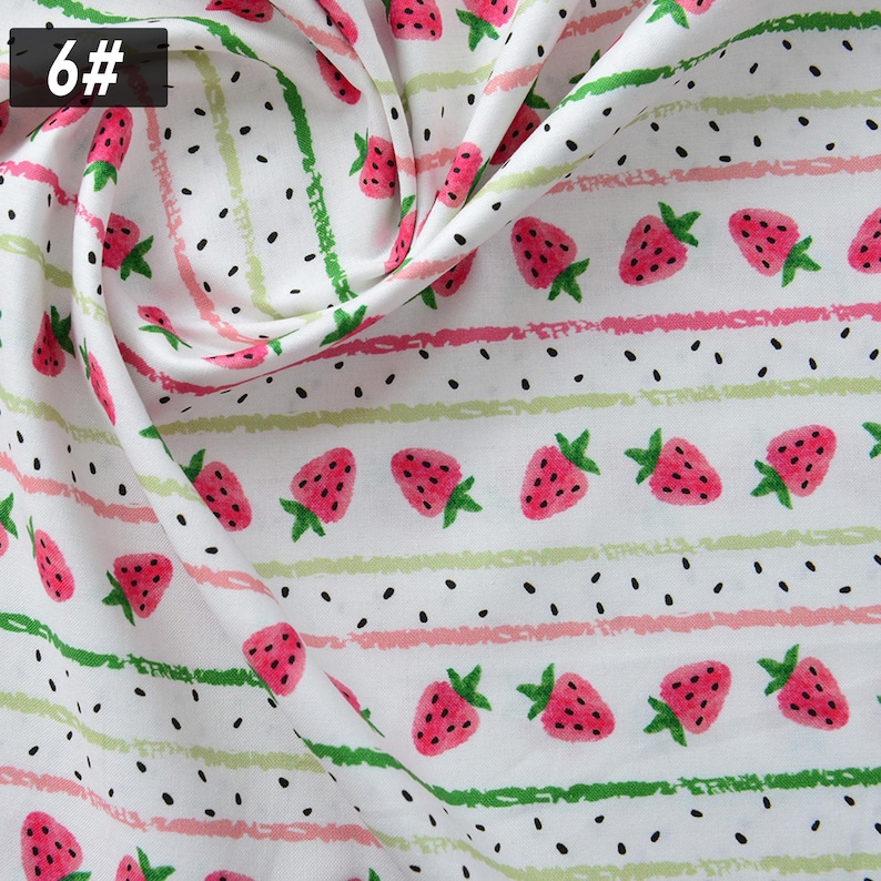 Puede incluir: Tela blanca con un patr&oacute;n repetitivo de fresas rosas, hojas verdes y semillas negras. El dise&ntilde;o incluye rayas horizontales rosas y verdes. El n&uacute;mero "6#" se encuentra en la esquina superior izquierda.