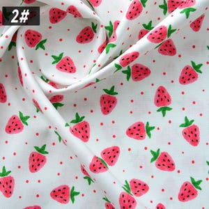 Puede incluir: Tela blanca con un patr&oacute;n repetido de fresas rojas y peque&ntilde;os puntos rojos. Las fresas tienen tallos verdes y semillas negras. El n&uacute;mero "2#" est&aacute; en un cuadro negro en la esquina superior izquierda.