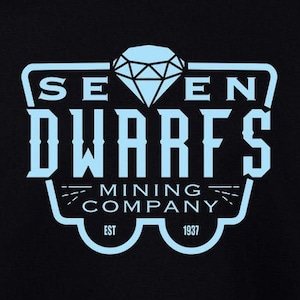 Pode incluir: Camisola de moletom preta com um gráfico azul claro de um carrinho de mina com o texto "SEVEN DWARFS MINING COMPANY EST 1937" e um diamante.