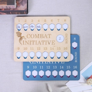 May include: Two wooden game boards with the text "COMBAT INITIATIVE". The top board is light wood with a dragon graphic and the bottom board is blue. Each board has numbered slots for game pieces.