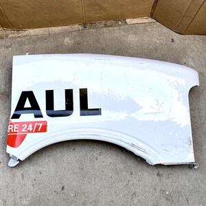 Könnte beinhalten: Weißer Kunststoff-LKW-Kotflügel mit schwarzem "AUL"-Logo und rotem "RE 24/7"-Aufkleber.