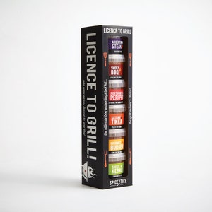 May include: A black box with a clear window showing five small jars of spices. The jars are labeled with different flavors, including Argentinian Steak, Smoky BBQ, Portuguese Peri Peri, Sizzling Tikka, Gourmet Burger, and Shish Kebab. The box is labeled "Licence to Grill!" and "The grill master's choice!"