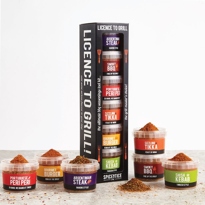 May include: A set of six spice jars with different flavors, including Argentinian Steak, Smoky BBQ, Portuguese Peri Peri, Sizzling Tikka, Gourmet Burger, and Shish Kebab. The jars are arranged in a vertical stack with the text "Licence to Grill!" on the front.