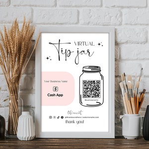May include: A white framed poster with a black and white illustration of a mason jar with a QR code. The text "VIRTUAL Tip jar" is at the top of the poster. The text "Your Business Name" is below the jar. The text "S Cash App" is below the business name. The text "Sbusinessname" is below the QR code. The text "@brandsocialhere | websitename.com" is below the jar. The text "thank you!" is at the bottom of the poster.