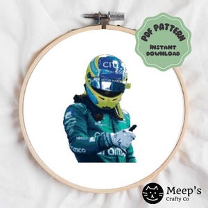 Puede incluir: Patrón de punto de cruz de un piloto de Fórmula 1 con un traje de carreras verde, azul y amarillo y un casco. El piloto está haciendo un pulgar hacia arriba. El patrón está sobre un fondo blanco.