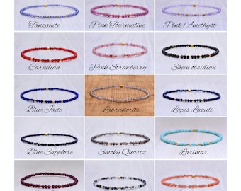 May include: A collection of delicate gemstone bracelets, each featuring a different stone and gold-colored accents. The image showcases bracelets with stones like Tanzanite, Pink Tourmaline, and Carnelian. Each bracelet is strung on a thin, clear cord.