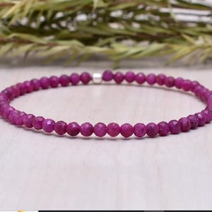 Op de afbeelding: Een delicate armband van roze edelstenen met een zilveren sluiting. De armband is gemaakt van kleine, gefacetteerde kralen.