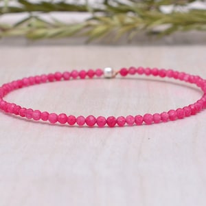 May include: A delicate pink gemstone bracelet with small, faceted beads. The bracelet is made with a silver clasp.