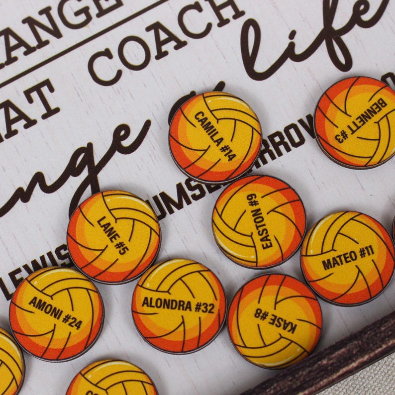 May include: A collection of circular pins featuring a yellow and orange volleyball graphic. Each pin is personalized with a name and a jersey number, including CAMILA #14, BENNETT #3, LANE #5, EASTON #9, MATEO #11, AMONI #24, ALONDRA #32, and KASE #8.