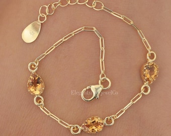 May include: A gold-toned chain bracelet featuring three pear-shaped, faceted yellow gemstones spaced evenly along the links. The bracelet includes a lobster claw clasp and an extender chain with a small teardrop-shaped tag stamped with 925.