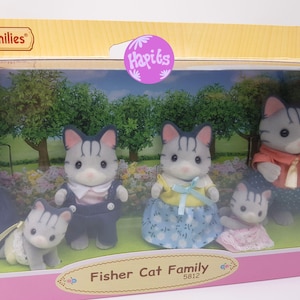 May include: A Fisher Cat Family set of four figurines, including a father, mother, son, and daughter. The family is dressed in blue, yellow, and pink clothing. The figurines are in a clear plastic box with a pink and white background. The box has the words "Fisher Cat Family" and "5812" printed on it.