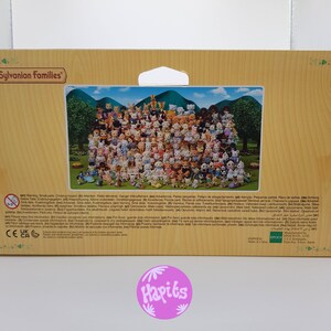 May include: A colorful box with a picture of a large group of Sylvanian Families figurines. The box is brown and has a white label with the words "Sylvanian Families" in black text. The back of the box has a warning label in multiple languages.