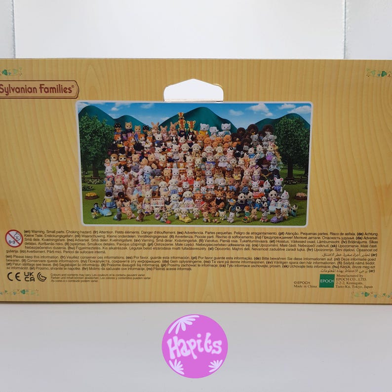 May include: A colorful box with a picture of a large group of Sylvanian Families figurines. The box is brown and has a white label with the words "Sylvanian Families" in black text. The back of the box has a warning label in multiple languages.