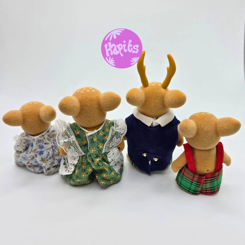 May include: Four miniature deer figurines, each with a unique outfit. One wears a blue floral dress, another a green dress with white lace, a third a navy blue vest, and the last a plaid overall. A purple circle with text is in the background.