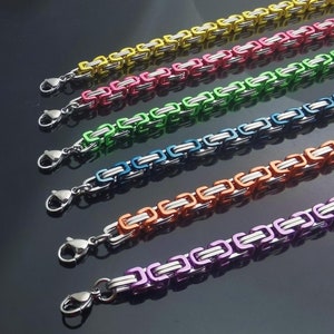 May include: A collection of six Byzantine chain bracelets featuring alternating silver-tone metal links and vibrant colored links in yellow, pink, green, blue, orange, and purple. Each bracelet is finished with a silver-tone metal lobster claw clasp.