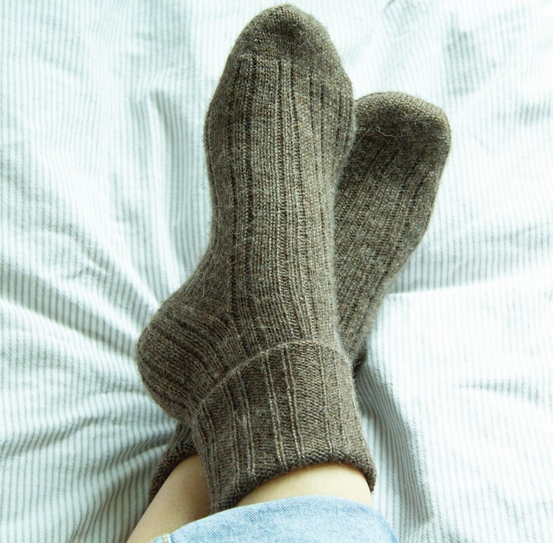 May include: A pair of brown ribbed socks with a white background.