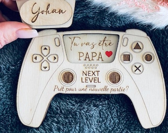 Original pregnancy announcement in the shape of a game controller, the future dad will discover this magnificent message under the small engraved cover