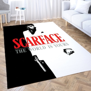 May include: A white and black area rug with a black and white image of a man with the text "Scarface The World Is Yours" in red.