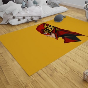 Puede incluir: Una alfombra amarilla con una ilustración de dibujos animados de Flash en un traje rojo con la palabra "FLASH" en letras amarillas en el pecho.