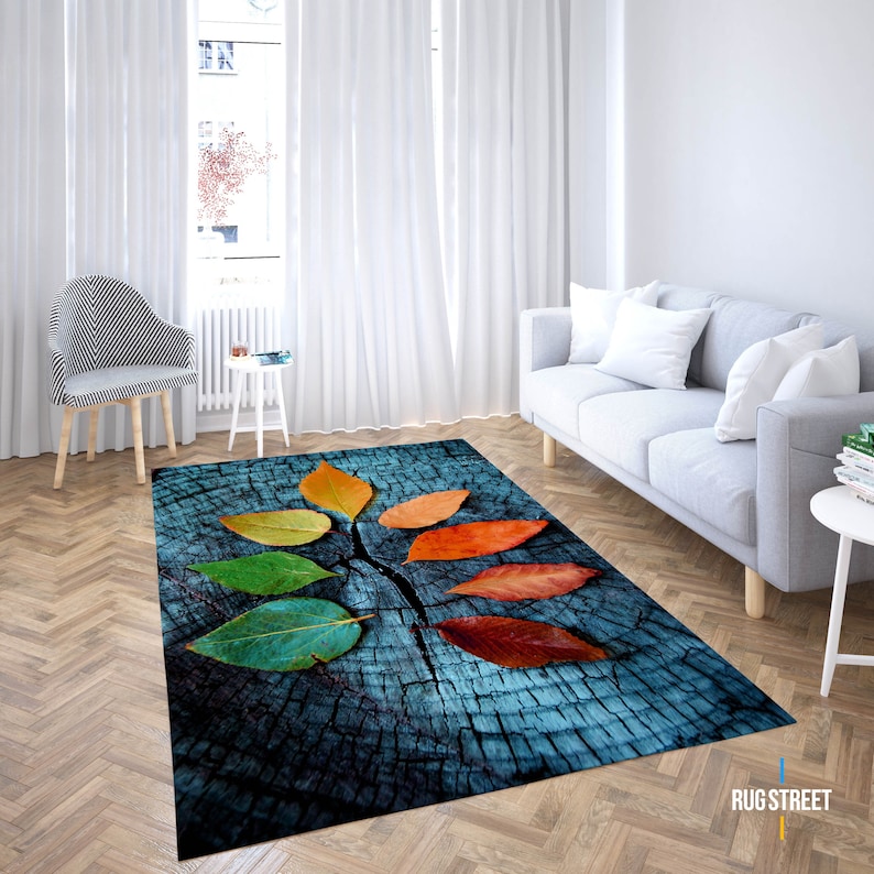 May include: A blue and brown rug with a design of colorful leaves on a wooden surface.