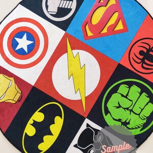 May include: A round rug with a black background and a colorful patchwork design featuring various superhero logos, including Superman, Batman, Captain America, Iron Man, The Flash, Hulk, Thor, and Spiderman. The rug has a black border and the word "Sample" is written in white on a red star.