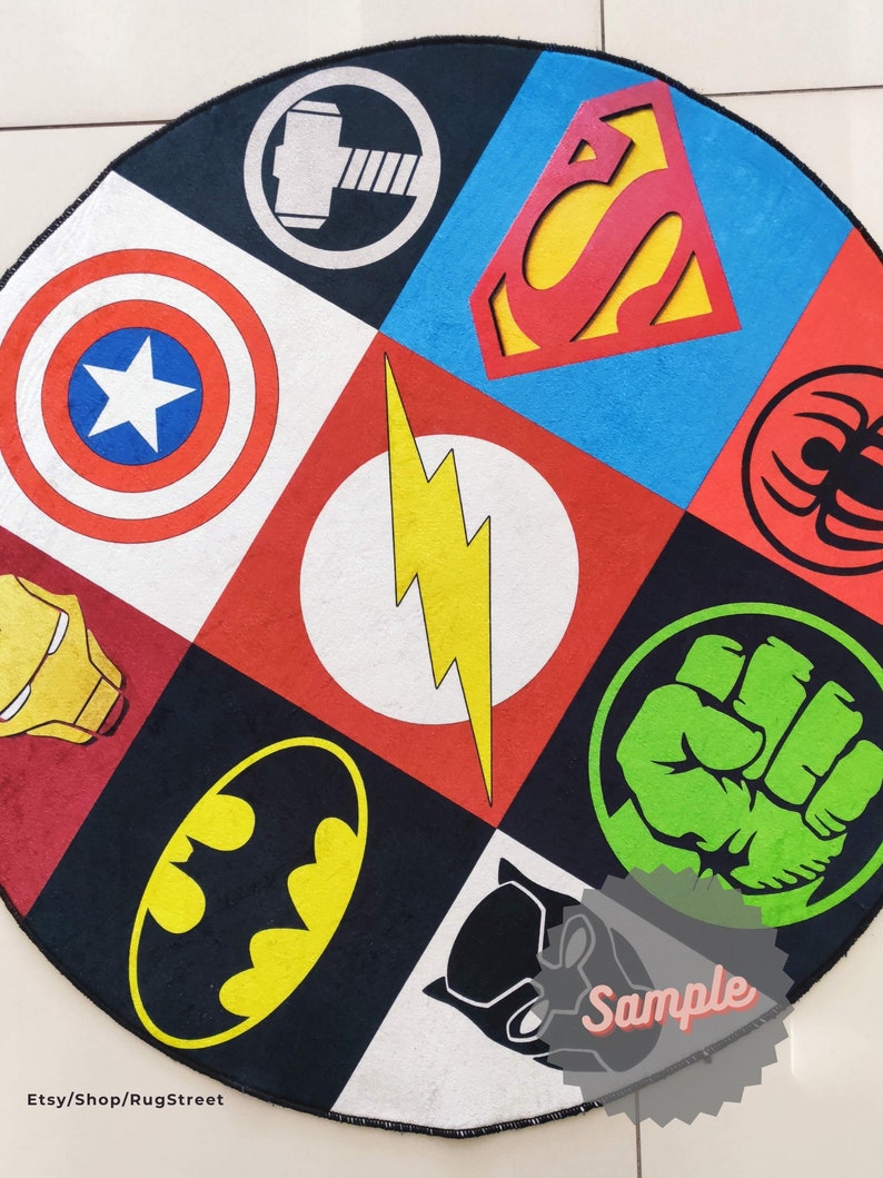 May include: A round rug with a black background and a colorful patchwork design featuring various superhero logos, including Superman, Batman, Captain America, Iron Man, The Flash, Hulk, Thor, and Spiderman. The rug has a black border and the word "Sample" is written in white on a red star.