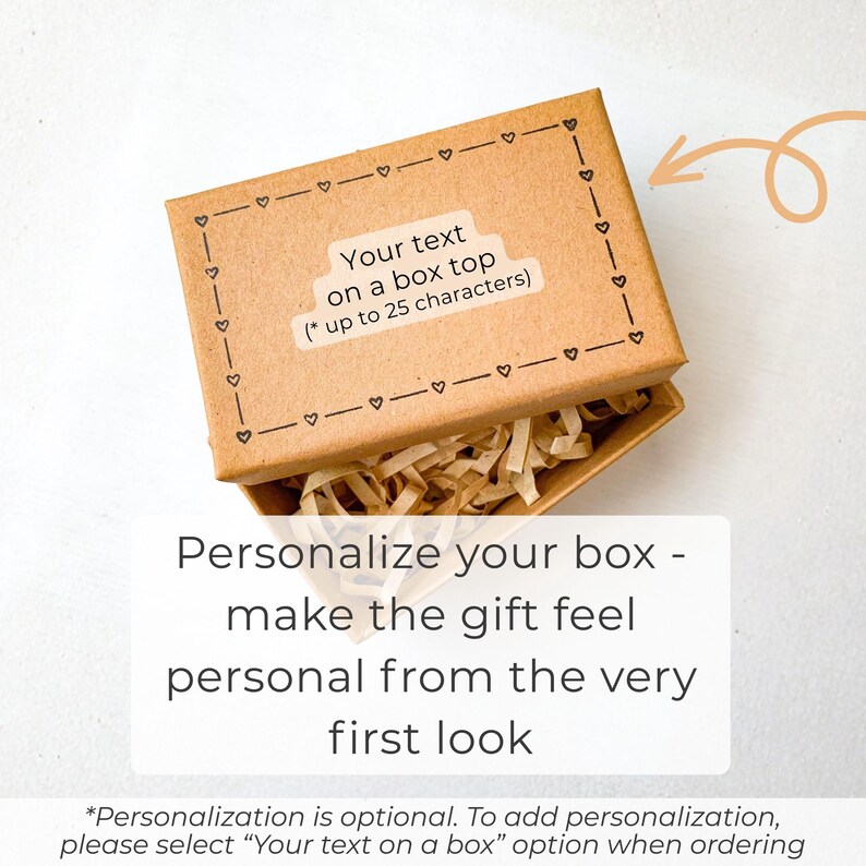 May include: A brown gift box with a decorative heart border and the text "Your text on a box top (* up to 25 characters)". The box is open, revealing shredded paper. The text below reads "Personalize your box - make the gift feel personal from the very first look."