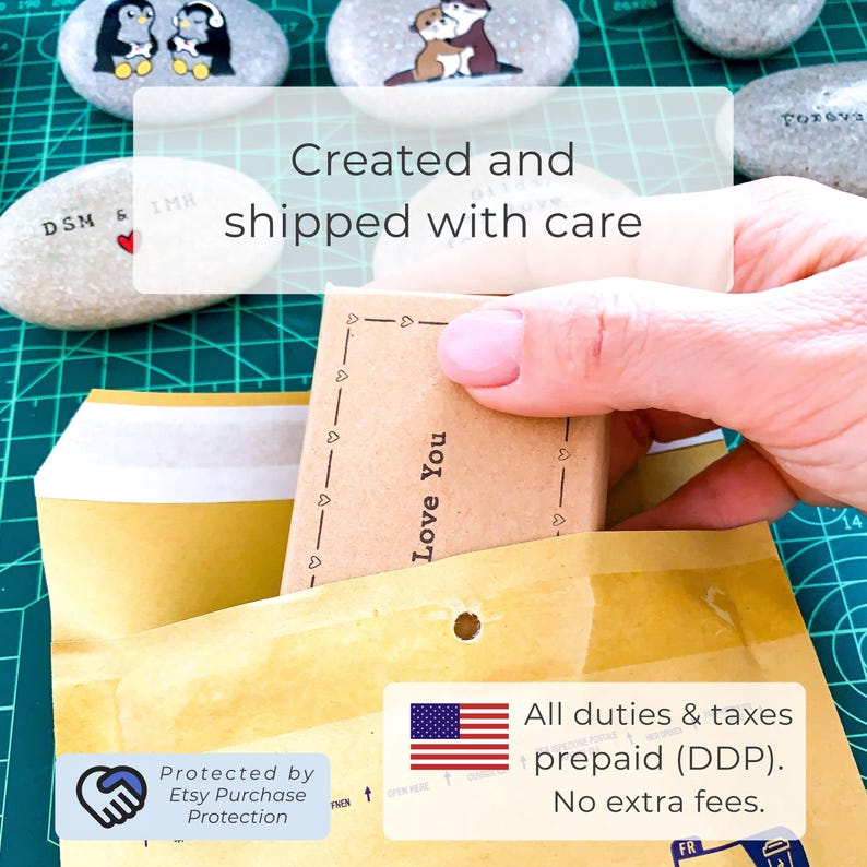 May include: A small, brown rectangular package labeled "Love You" is being placed into a yellow envelope. The image includes painted rocks with animal designs and text that reads "Created and shipped with care."