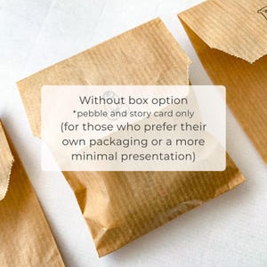 May include: Three brown paper packages, with a white rectangle overlay containing text. The text reads: "Without box option *pebble and story card only (for those who prefer their own packaging or a more minimal presentation)".