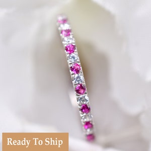 Può includere: Un delicato anello di eternità con pietre preziose rosa e bianche alternate. L'anello è incastonato in argento e ha una finitura lucida.