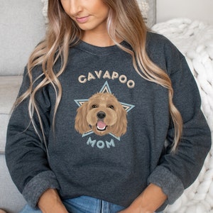 May include: A dark heather grey sweatshirt with a graphic of a cavapoo dog inside a star with the text "Cavapoo Mom".