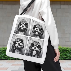 May include: A white tote bag with a black handle features a black and white photo collage of a dog wearing sunglasses. The dog is in four different poses, each with a different expression.