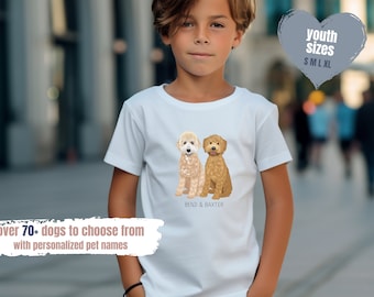 Może przedstawiać: Biała koszulka dla młodzieży z grafiką dwóch psów pudeli, jednego jasnobrązowego i jednego kremowego, z tekstem "BENJI & BAXTER". Koszulka dostępna jest w rozmiarach S, M, L i XL.