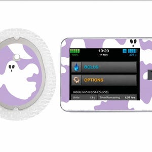 May include: A medical device skin set featuring a light purple background with a white ghost pattern. The set includes a circular adhesive patch and a rectangular insulin pump cover with a digital display showing 10:20, 14 Nov, Bolus, Options, and IOB.