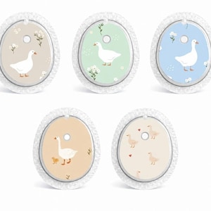 May include: Five oval adhesive patches for medical sensors, each featuring a white goose illustration. The designs include beige, light green, light blue, orange, and cream backgrounds with various floral accents and small heart motifs.
