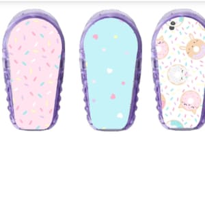 Könnte beinhalten: Drei farbige Aufkleber mit Mustern für ein medizinisches Gerät. Die Aufkleber zeigen ein rosa-weißes Streuselmuster, ein hellblaues Muster mit weißen Herzen und ein weißes Muster mit Donuts und Streuseln.