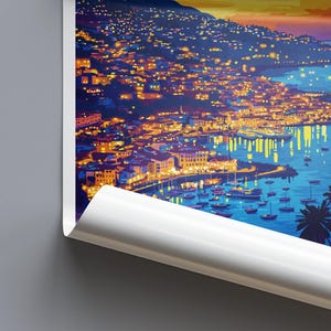 Op de afbeelding: Een levendige kunstafdruk die een kustplaats in de schemering uitbeeldt. De illustratie toont gebouwen met warme lichten die weerspiegelen in het water. Palmbomen en boten dragen bij aan het schilderachtige uitzicht, met een oranje en blauwe gradi&euml;nthemel.