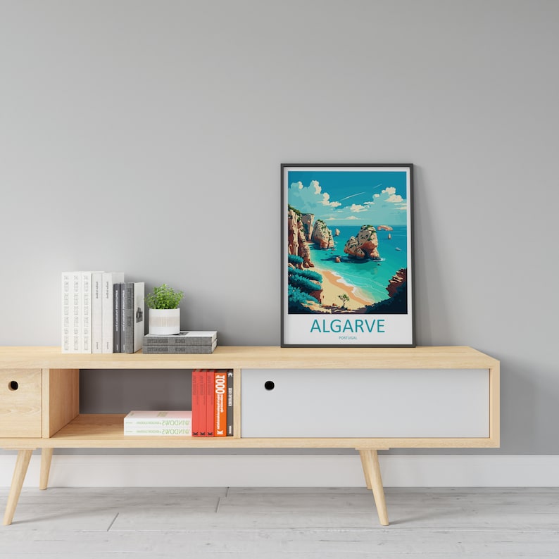 May include: A framed print of a beach scene in Algarve, Portugal. The print features a blue sky with white clouds, a sandy beach, turquoise water, and rocky cliffs. The text "ALGARVE PORTUGAL" is printed below the image.