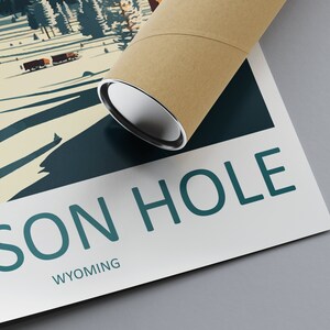 May include: A vintage-style poster with a teal blue and white design featuring a snowy mountain landscape and the text "JACKSON HOLE WYOMING". The poster is rolled up and ready to be displayed.
