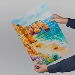 May include: A vibrant watercolor painting of a coastal landscape featuring golden cliffs, turquoise water, and a sandy beach. The artwork depicts a sunny day with a clear sky and colorful vegetation.